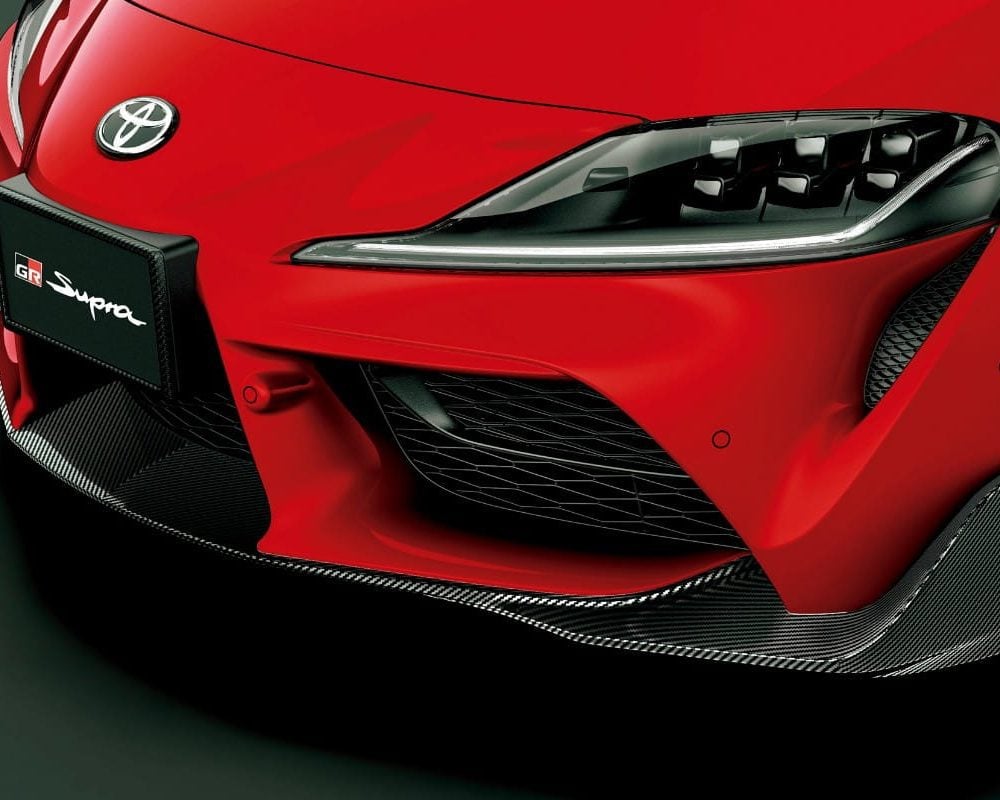Toyota Gazoo Racing Carbon GR Front Spoiler for A90 / A91 Toyota Supra Installed on Red Supra - Close Front-side View of Car