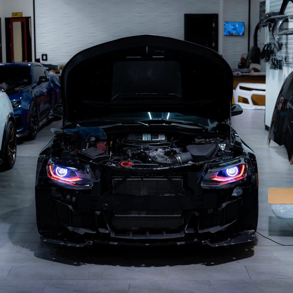 Auto Addict OEM Replica Projector Headlights with RGBW Lighting for 6th Gen Chevrolet Camaro LT, RS, and SS (pre-facelift) / ZL1 Installed on Black Camaro with Red DRL and Purple Demon Eye - Front View of Car