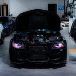 Auto Addict OEM Replica Projector Headlights with RGBW Lighting for 6th Gen Chevrolet Camaro LT, RS, and SS (pre-facelift) / ZL1 Installed on Black Camaro with Red DRL and Purple Demon Eye - Front View of Car